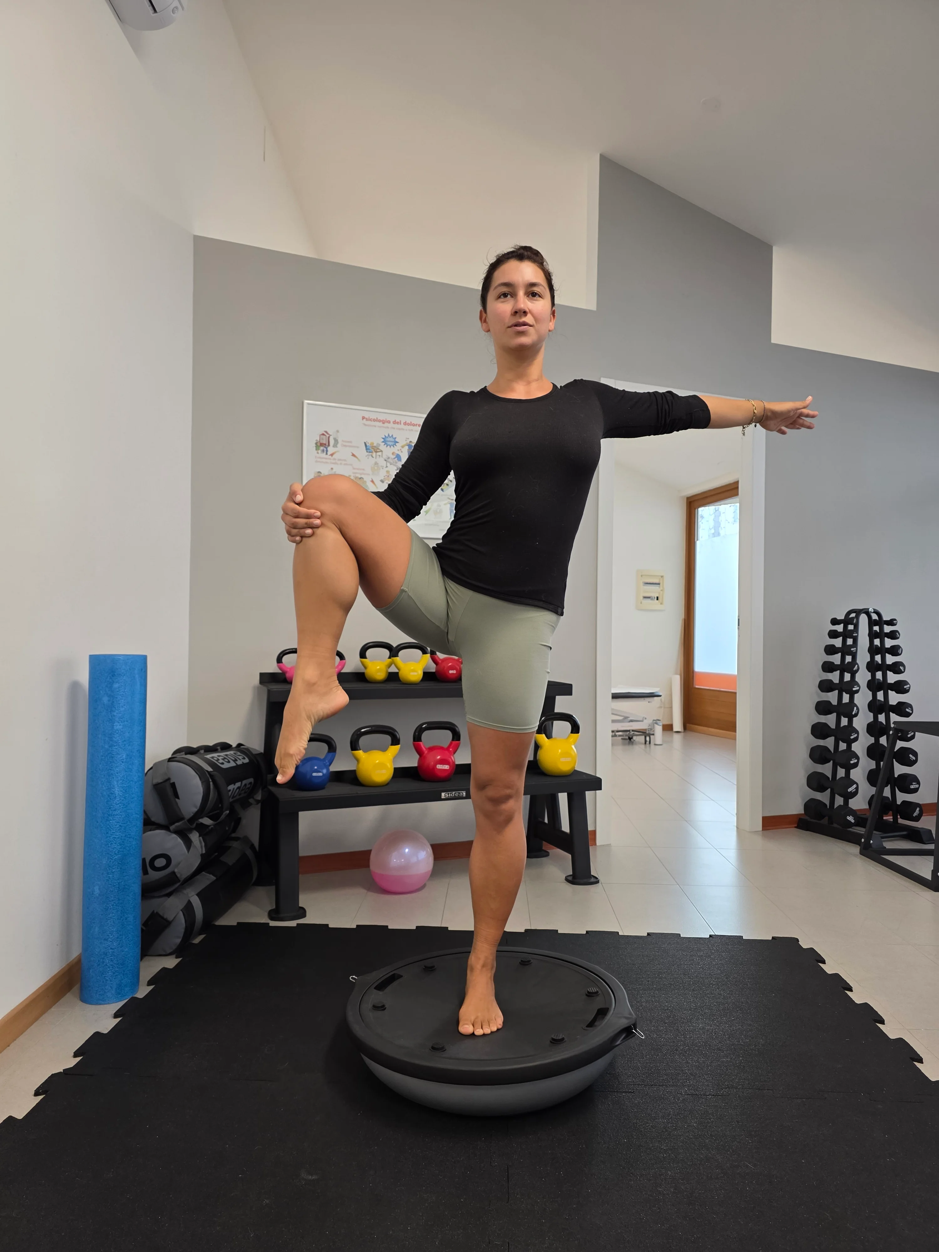 Una persona esegue un esercizio di equilibrio su una pedana instabile.